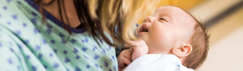 A newborn baby looking at their mother